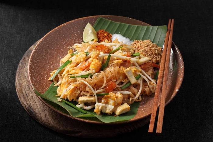 Pad Thai, món ăn đường phố nổi tiếng, món ăn Thái truyền thống trên nền tối và không gian trống.