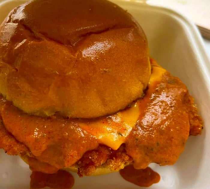 A crispy fried chicken sandwich topped with melted cheese.