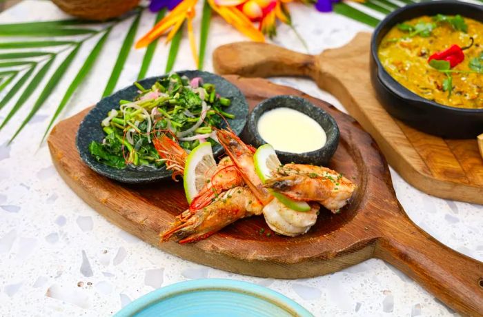 Succulent prawn heads served alongside a vibrant salad and flavorful sauce.