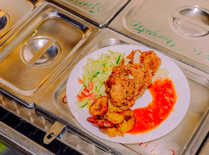 A dish featuring meat, plantains, and vegetables arranged on a plate.