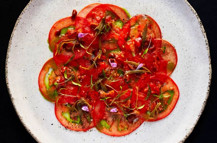 Tomato slices garnished with delicate microgreens.