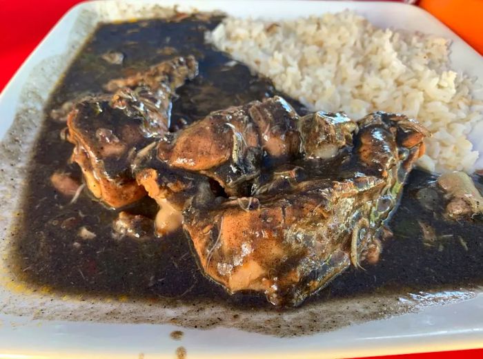 Chicken served in a rich, dark sauce accompanied by rice.