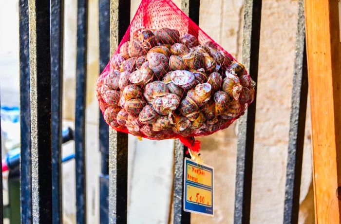 A bag of fresh snails is displayed outside.