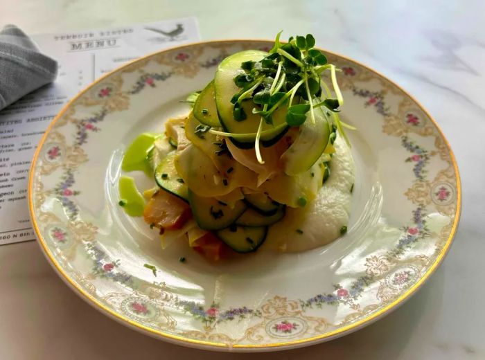 A vintage-style plate with cucumbers and microgreens elegantly arranged on top.