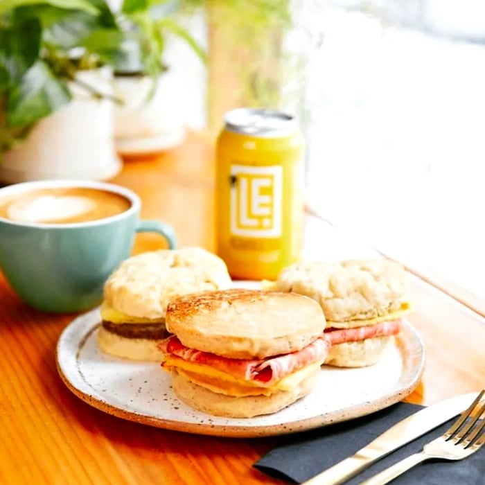 Three assorted biscuits paired with a coffee and a can, resting on a sunny windowsill.