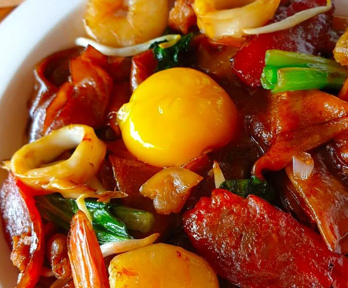 A close-up of a vibrant egg yolk nestled in a stir-fry.