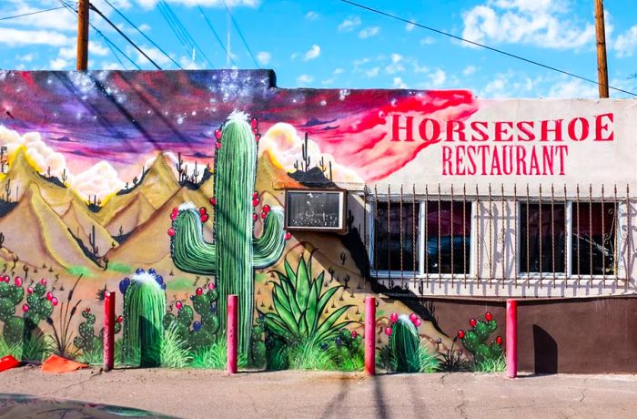 The exterior of Horseshoe Restaurant showcases a mural of a saguaro cactus.