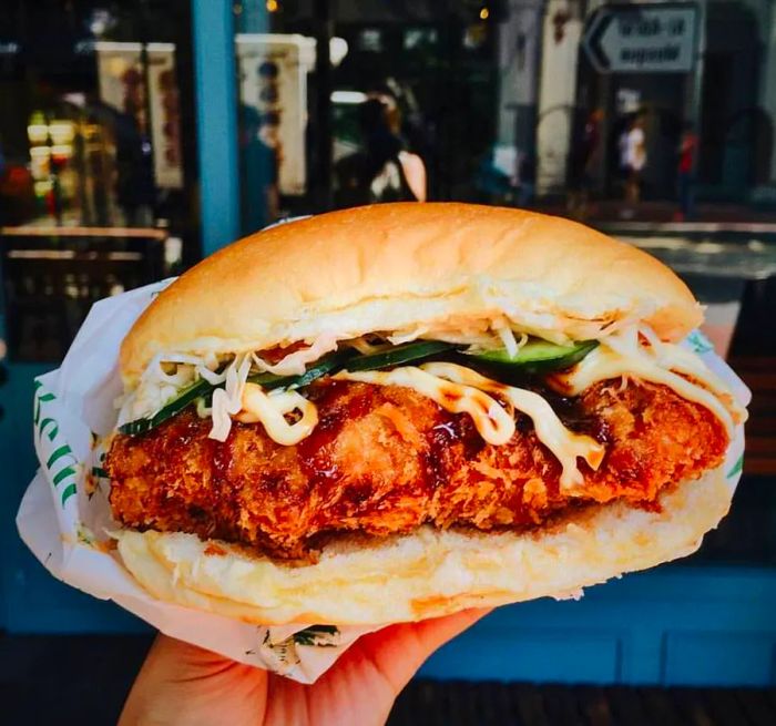 A decadent, oversized chicken katsu sandwich overflowing with flavor.