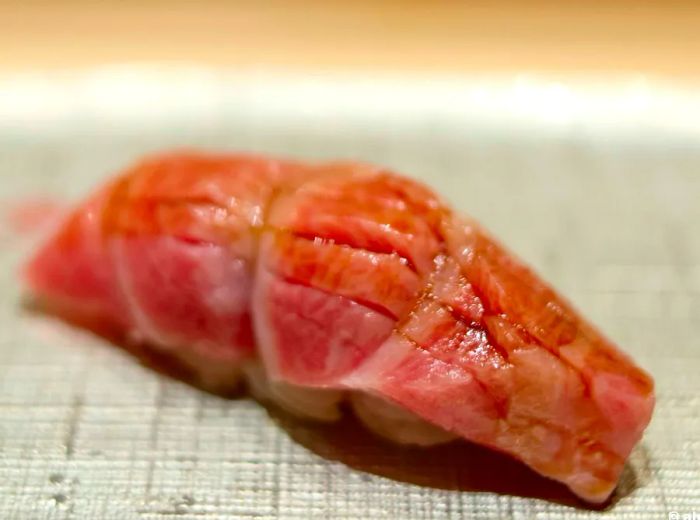 A close-up of a marbled piece of nigiri sushi.