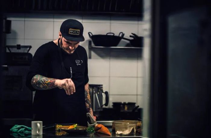 Chef Safe Cruz is seen from a distance seasoning a dish in Gofio's kitchen.