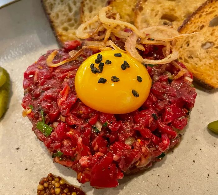 A generous serving of steak tartare crowned with a raw egg yolk.