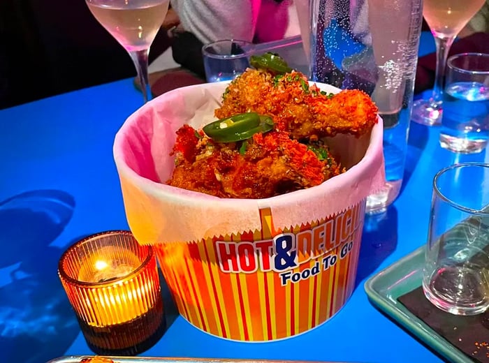 A table laden with a bucket of crispy fried chicken and a selection of refreshing drinks.