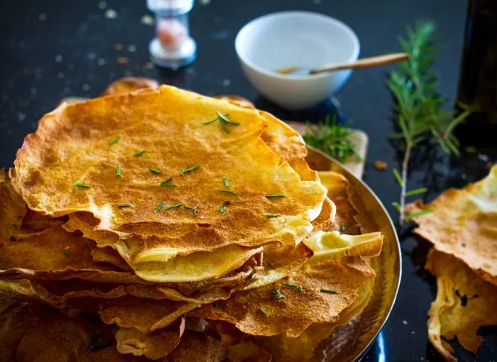 A stack of wafer-thin pane carasau topped with fresh herbs