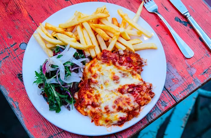 A parma crowned with cheese, served with fries and a side salad