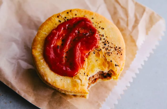 A dollop of tomato sauce is the classic topping for a traditional meat pie, delivering a burst of flavor in every bite.