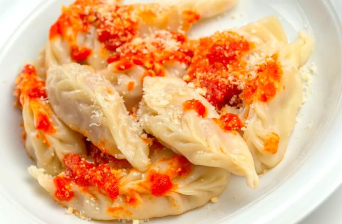 Succulent, dumpling-like culugriones adorned with tomatoes and cheese