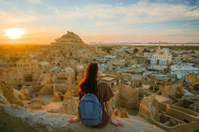 Woman gazing at the sunset over the scenic Siwa Oasis