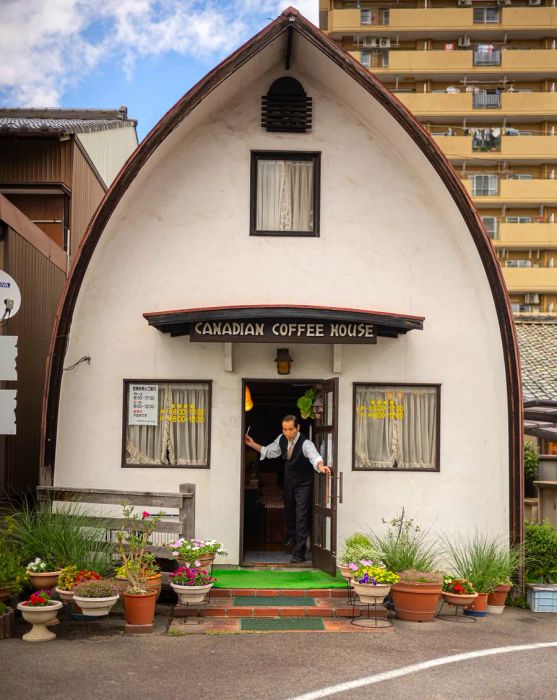 Mr. Sakai reaches out to close the door at Canadian Coffee House