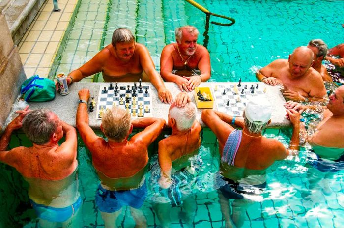 A group of men enjoying a game of chess in an outdoor pool at Budapest’s Széchenyi Baths.