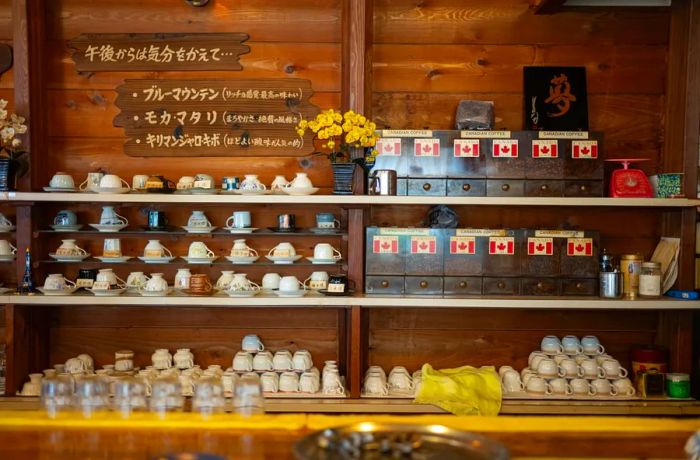 A row of coffee cups neatly arranged behind the bar at Canadian Coffee House