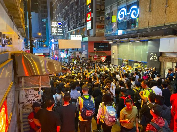 Crowds gather in front of a police line