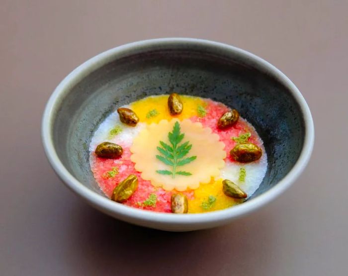 A vibrant bowl of granitas, beautifully layered and garnished with pistachios.