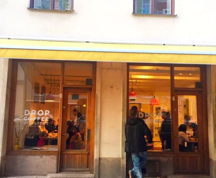 A café's facade, showcasing customers enjoying their time inside through expansive windows.