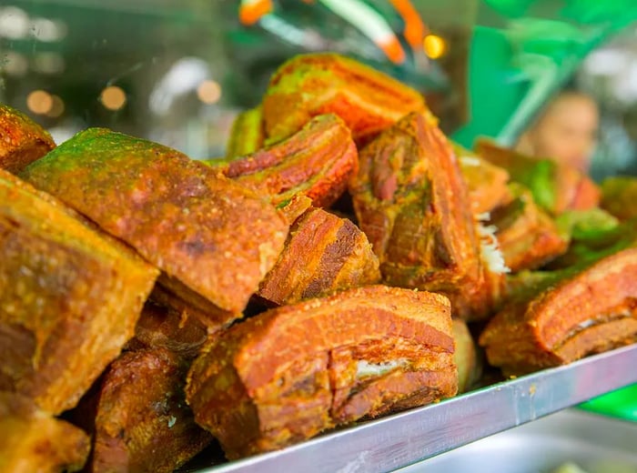 A metal tray filled with stacked pork rinds.