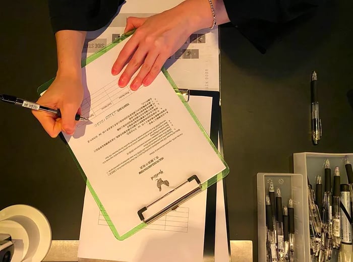 A health declaration form is being filled out on a clipboard.