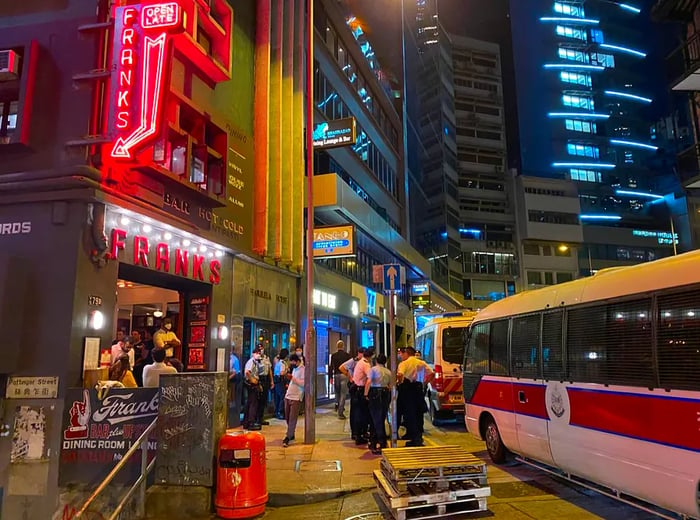 A police bus is parked outside Frank’s, where officers can be seen standing guard in front of the establishment.