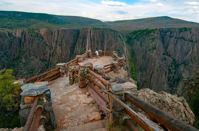  A female hiker gazes into the vast canyon from a major viewpoint.