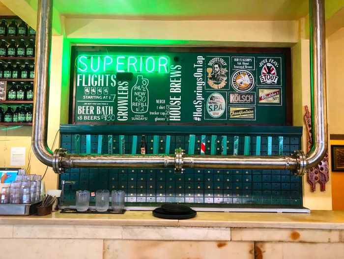 a colorful neon sign above a row of beer taps.