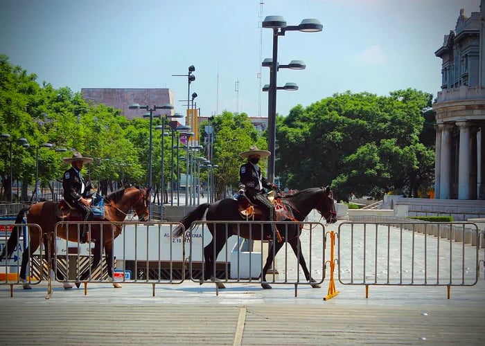 In Mexico City, police officers wearing face masks ride horses down the streets.