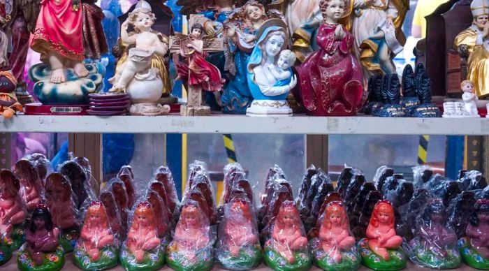 Small figurines of a young girl arranged on shelves.