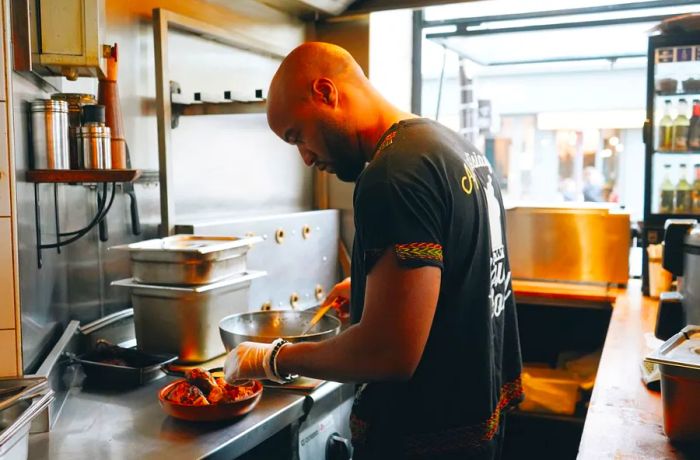 Rudy Lainé is busy in the narrow kitchen of the restaurant, skillfully preparing dishes on the stainless steel counter.