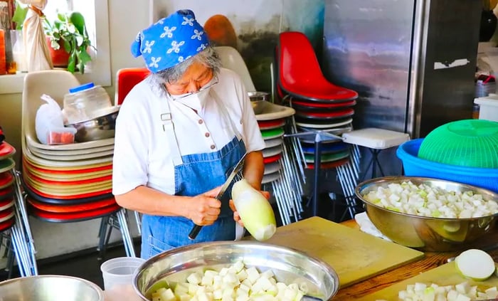 A chef chops Korean radish into large bowls