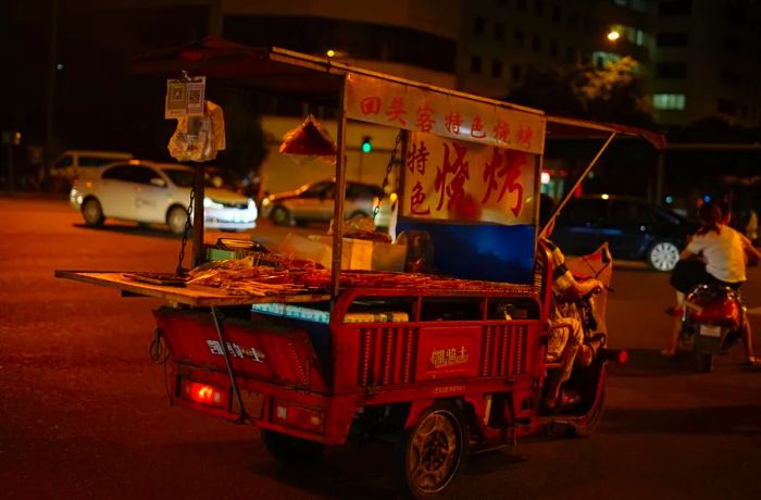 A small food cart rolls down the street.