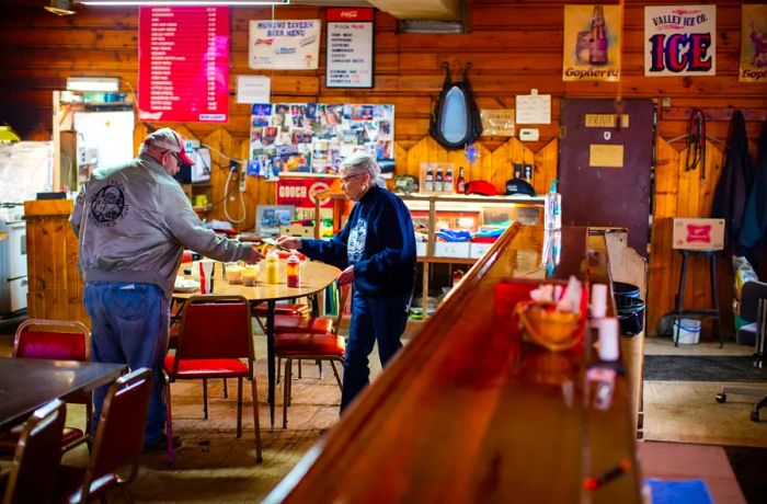 Elsie serves a customer in the tavern.