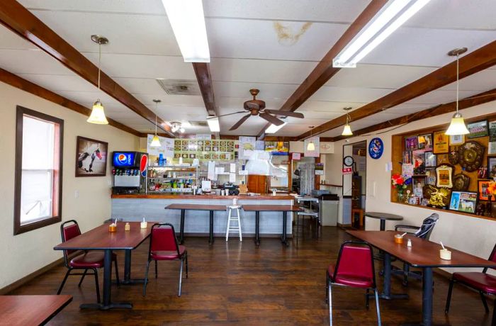 A dining area featuring four varied tables around an ordering counter.