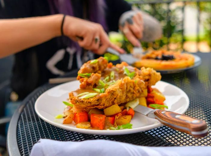 A plate of fried steak smothered in gravy on an outdoor table