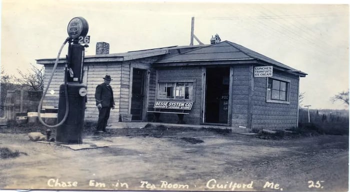 A nostalgic image capturing an old building alongside a fuel pump.