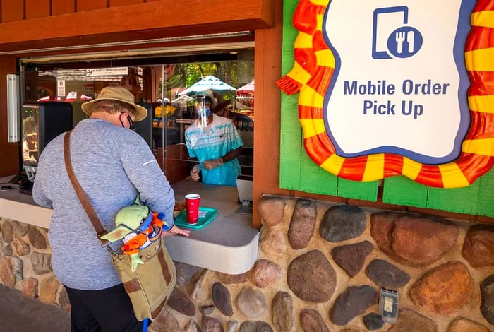 A man collects his meal from a service window.