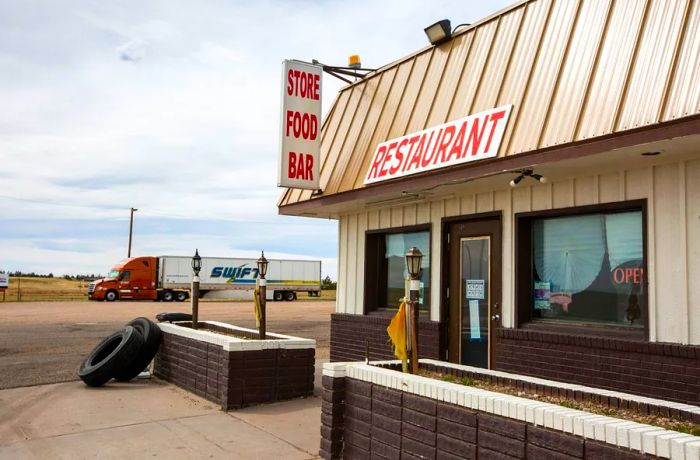 The front corner of a building features a sign hanging from the roof that reads 'Store Food Bar,' with an additional sign on the roof stating 'Restaurant.'