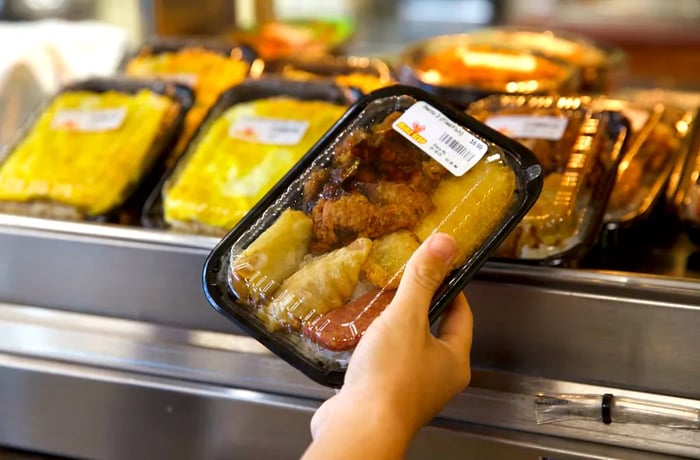 A takeout container filled with steaming hot food.