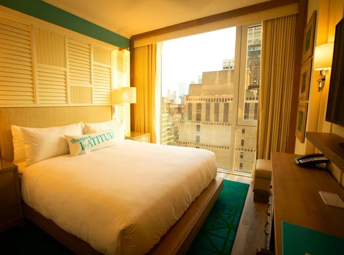 A hotel room featuring a bed with a view of the city skyline.