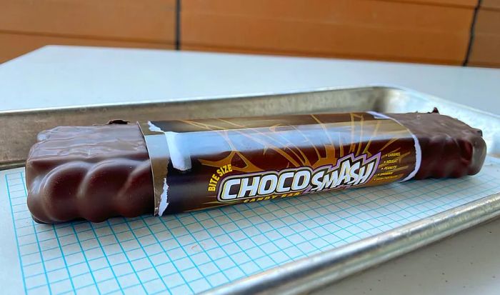 A brown chocolate candy bar resting on a tray.