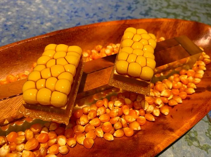 spherical corn placed atop a bowl filled with dried corn kernels