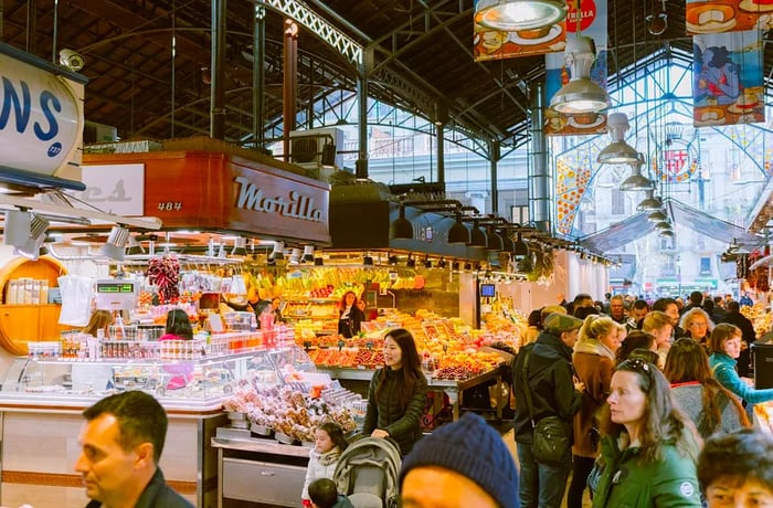 The spacious main atrium filled with bustling crowds navigating between the vendors.