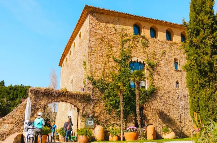 A stone building draped in vines.