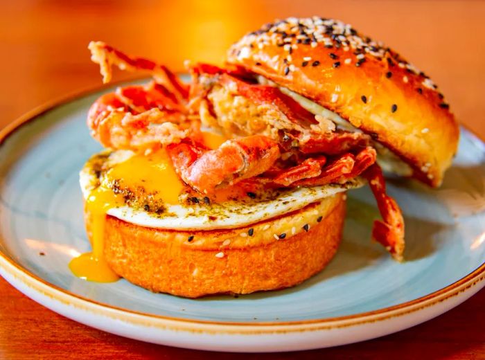 A soft-shell crab atop a runny egg, nestled in a sesame bun.